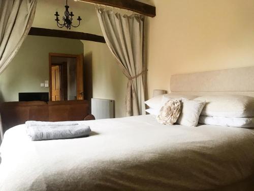 a bedroom with a large bed with white sheets and pillows at Oak Barn in Wigginton