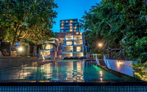 a swimming pool in front of a building at night at Centara Q Resort Rayong in Mae Pim