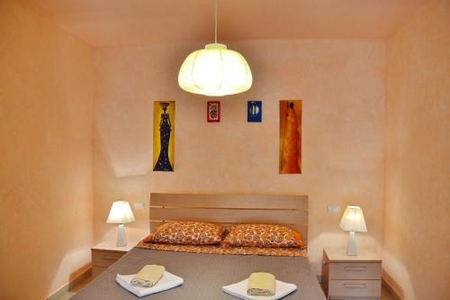 薩爾雷的住宿－Comfortable and spacious apartment with ocean views of Cabral beach，一间卧室配有一张带两张桌子和两盏灯的床。