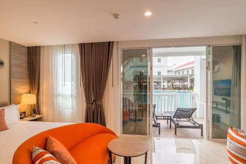 a bedroom with an orange couch and a balcony at Centara Ao Nang Beach Resort & Spa Krabi in Ao Nang Beach