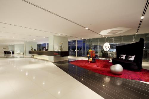 a living room with a red rug and a clock at Centara Watergate Pavilion Hotel Bangkok in Bangkok