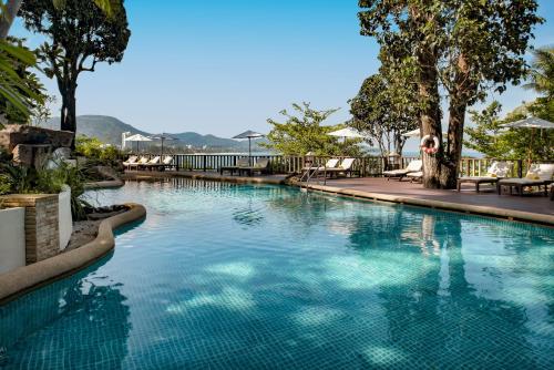 a swimming pool with blue water in a resort at Centara Villas Phuket in Karon Beach