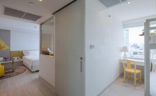 a room with a door leading to a bedroom with a bed at Centara Watergate Pavillion Hotel Bangkok - SHA Extra Plus Certified in Bangkok