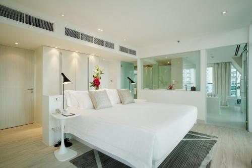 a large white bedroom with a large white bed at Centara Watergate Pavilion Hotel Bangkok in Bangkok