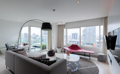 a living room with a couch and a table at Centara Watergate Pavilion Hotel Bangkok in Bangkok