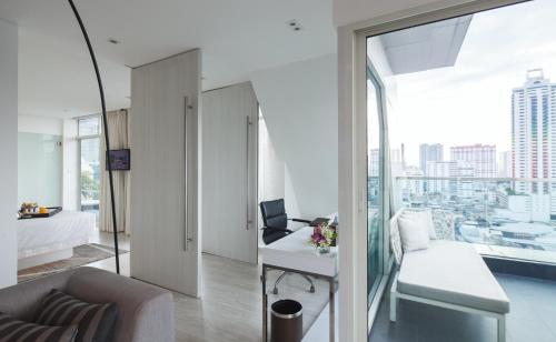 a room with a bed and a desk with a laptop at Centara Watergate Pavilion Hotel Bangkok in Bangkok