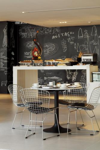 a table and chairs in a room with a chalk board at Centara Watergate Pavilion Hotel Bangkok in Bangkok