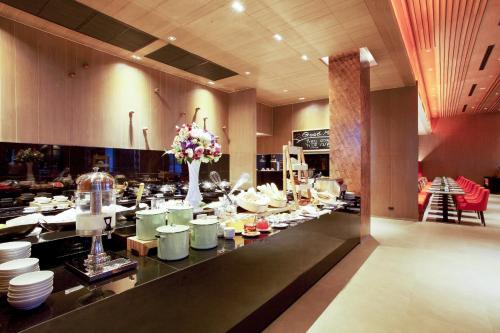a buffet line with white plates and flowers in a restaurant at Centara Life Maris Resort Jomtien in Jomtien Beach