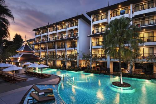 a hotel with a swimming pool in front of a building at Centara Anda Dhevi Resort & Spa Krabi in Ao Nang Beach