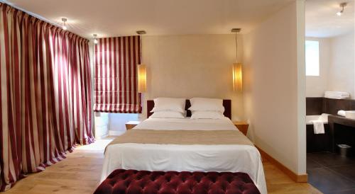 a bedroom with a large bed and a red couch at Au Vieux Moulin in Chablis