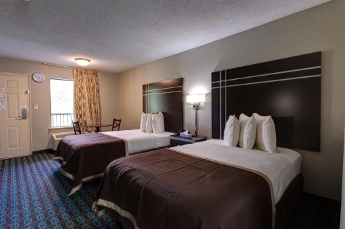 a hotel room with two beds and a window at Deluxe Inn - Fayetteville I-95 in Fayetteville