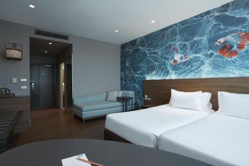 a hotel room with a bed and a couch at Centara Life Government Complex Hotel & Convention Centre Chaeng Watthana in Bangkok