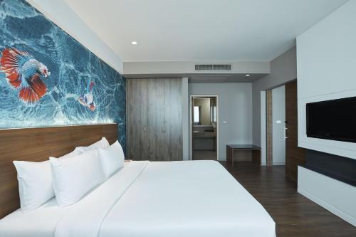 a bedroom with a large bed and a tv at Centara Life Government Complex Hotel & Convention Centre Chaeng Watthana in Bangkok
