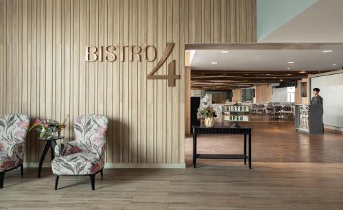 a lobby with two chairs and a sign on the wall at Centara Life Government Complex Hotel & Convention Centre Chaeng Watthana in Bangkok