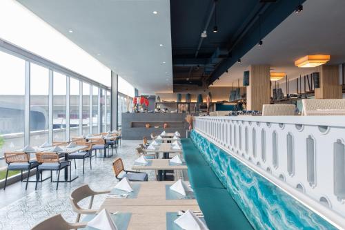 a restaurant with a pool and tables and chairs at Centara Life Government Complex Hotel & Convention Centre Chaeng Watthana in Bangkok