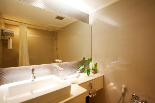 a bathroom with a sink and a mirror at Centara Hotel Hat Yai in Hat Yai