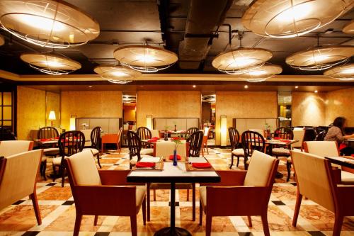 a restaurant with tables and chairs and people in the background at Centara Hotel Hat Yai in Hat Yai