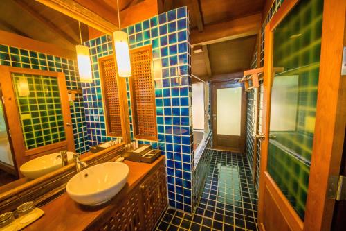 a bathroom with blue tiled walls and a sink at Centara Koh Chang Tropicana Resort in Ko Chang