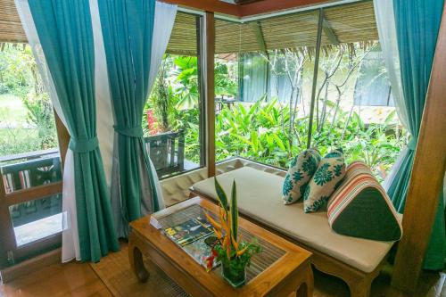 a living room with a couch and a table at Centara Koh Chang Tropicana Resort in Ko Chang