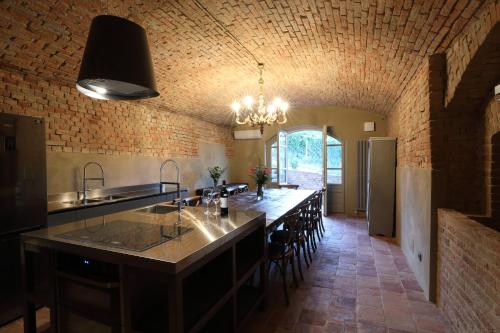 a large kitchen with a large island in a brick wall at Villa Giobatta in Barolo