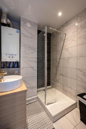 une salle de bain avec douche et lavabo dans l'établissement Le Grand Drancy - 3 chambres - tout équipé, à Drancy