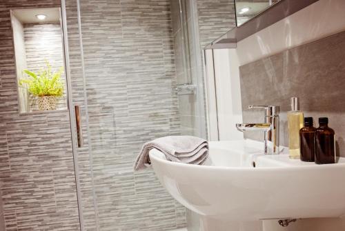 a bathroom with a white sink and a shower at The Dragon's Den in Harrogate