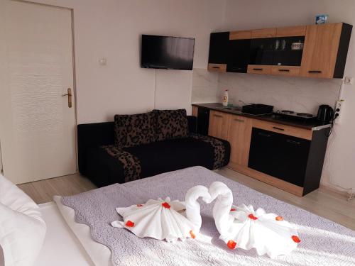 a hotel room with two white towels on a bed at Pensiunea Red Rose Apartments in Timişoara