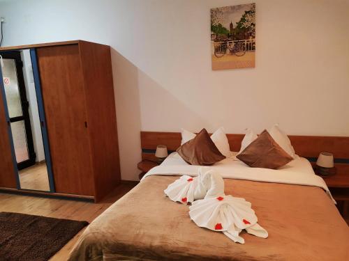 a bedroom with a bed with two towels on it at Pensiunea Red Rose Apartments in Timişoara