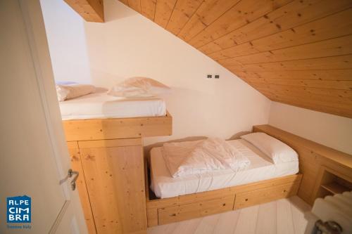 Cette chambre dispose de 2 lits superposés et de plafonds en bois. dans l'établissement Trentino Apartments - Casa Moser, à Folgaria