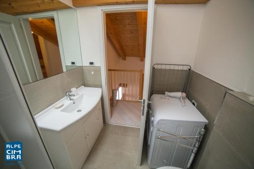 bagno con lavandino, servizi igienici e specchio di Trentino Apartments - Casa Moser a Folgaria