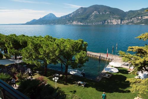 - une vue sur une grande étendue d'eau avec des montagnes dans l'établissement Hotel Du Lac - Relax Attitude Hotel, à Brenzone