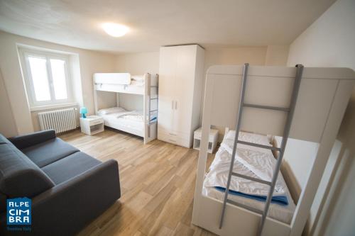 Trentino Apartments - Casa Marzari في فولاريا: غرفة معيشة مع سريرين بطابقين وأريكة