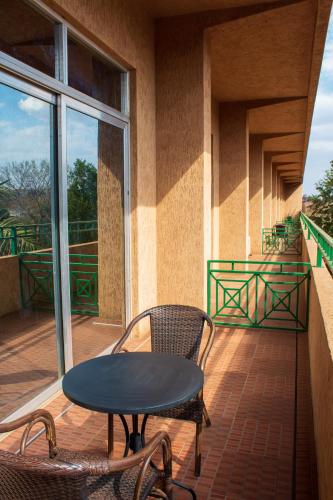 a patio with a table and chairs on a balcony at MalVille Boutique Hotel in Lilongwe