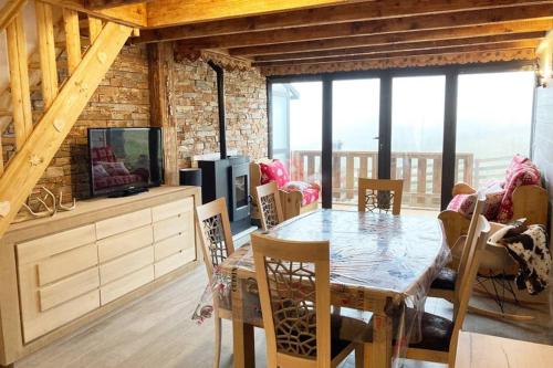 une salle à manger avec une table et une télévision dans l'établissement Chalet cosy rénové avec vue sur le lac, aux Angles
