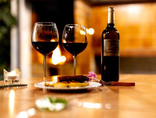 dos copas de vino y un plato de comida en una mesa en Es Fasser en Alcúdia