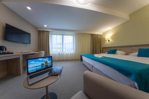 a hotel room with a bed and a laptop on a table at Hotel Siesta in Užice
