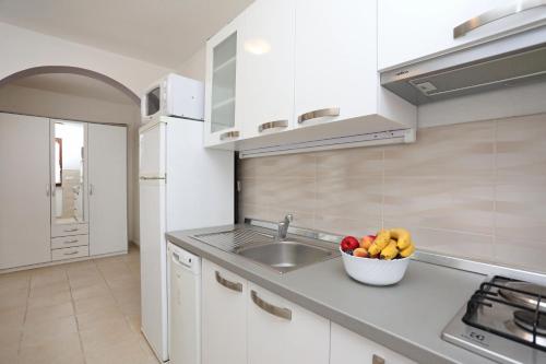 a kitchen with a sink and a bowl of fruit at Greenhouse family apartments in Rabac