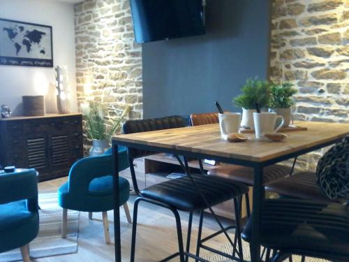 - une table et des chaises en bois dans le salon dans l'établissement appartement topaze, à Concarneau
