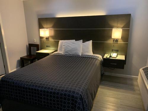 a hotel room with a bed and two night stands at Mirage Inn & Suites in San Francisco