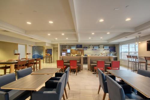 a dining room with wooden tables and chairs at Holiday Inn Express Hotel & Suites Oshkosh - State Route 41 by IHG in Oshkosh