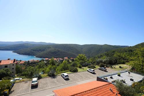 arial view of a parking lot next to a body of water at Greenhouse family apartments in Rabac