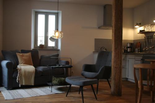 een woonkamer met een bank en een tafel bij Hej Ferienwohnung in Gau-Algesheim