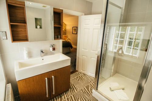 a bathroom with a sink and a shower at Boscundle Manor in St Austell