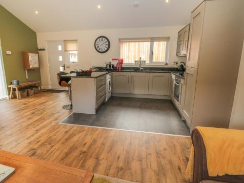 a kitchen with wooden floors and a clock on the wall at Barn Owl in Newcastle upon Tyne