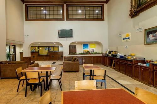 a restaurant with tables and chairs in a room at Days Inn & Suites by Wyndham Houston North/Aldine in Houston