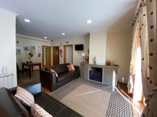 a living room with a couch and a fireplace at Casa Santa Catarina in Montalegre
