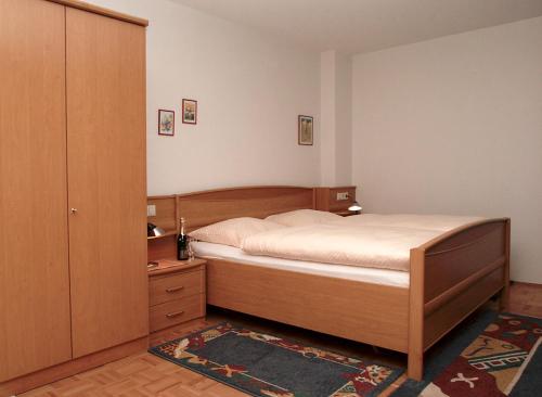 a bedroom with a bed and a dresser and a closet at Gästehaus-zum-See in Bad Buchau