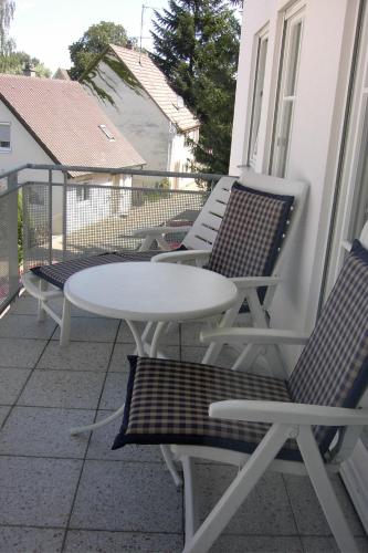 バート・ブーハウにあるGästehaus-zum-Seeの白いテーブルと椅子付きのバルコニー