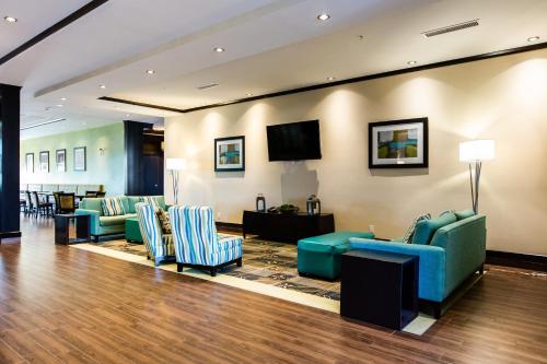 a lobby with couches and chairs and a flat screen tv at Holiday Inn Express & Suites Spruce Grove - Stony Plain, an IHG Hotel in Spruce Grove