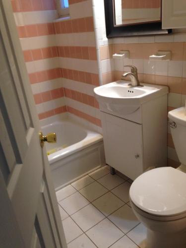 a bathroom with a sink and a toilet and a tub at Apt Near Downtown in Montreal